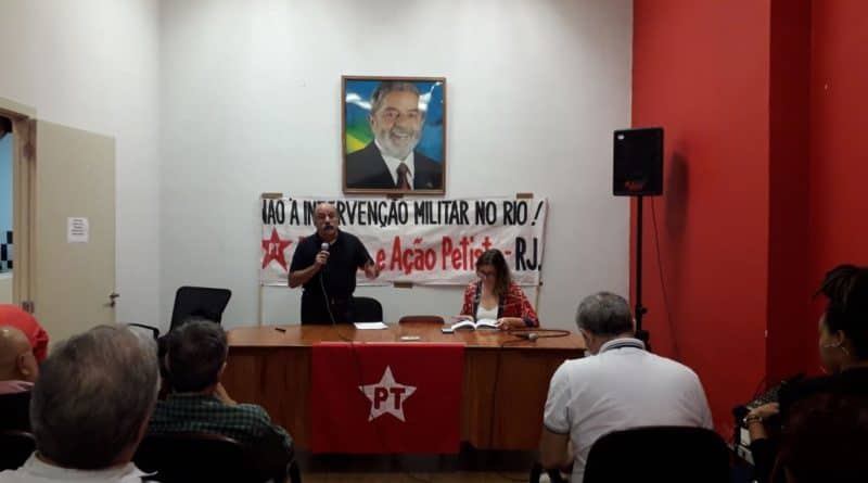 mesa do debate com foto do lula ao fundo