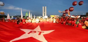 Povo segurando a bandeira do PT em Brasilia